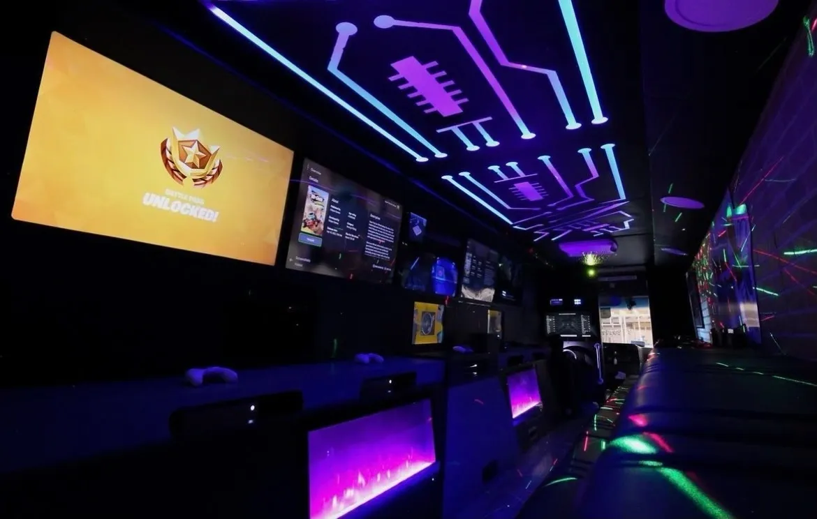 A room with several large screens and neon lights.