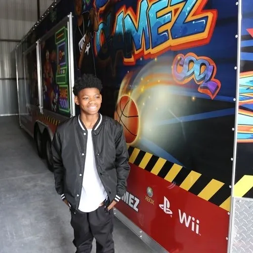 A young man standing in front of a video game truck.